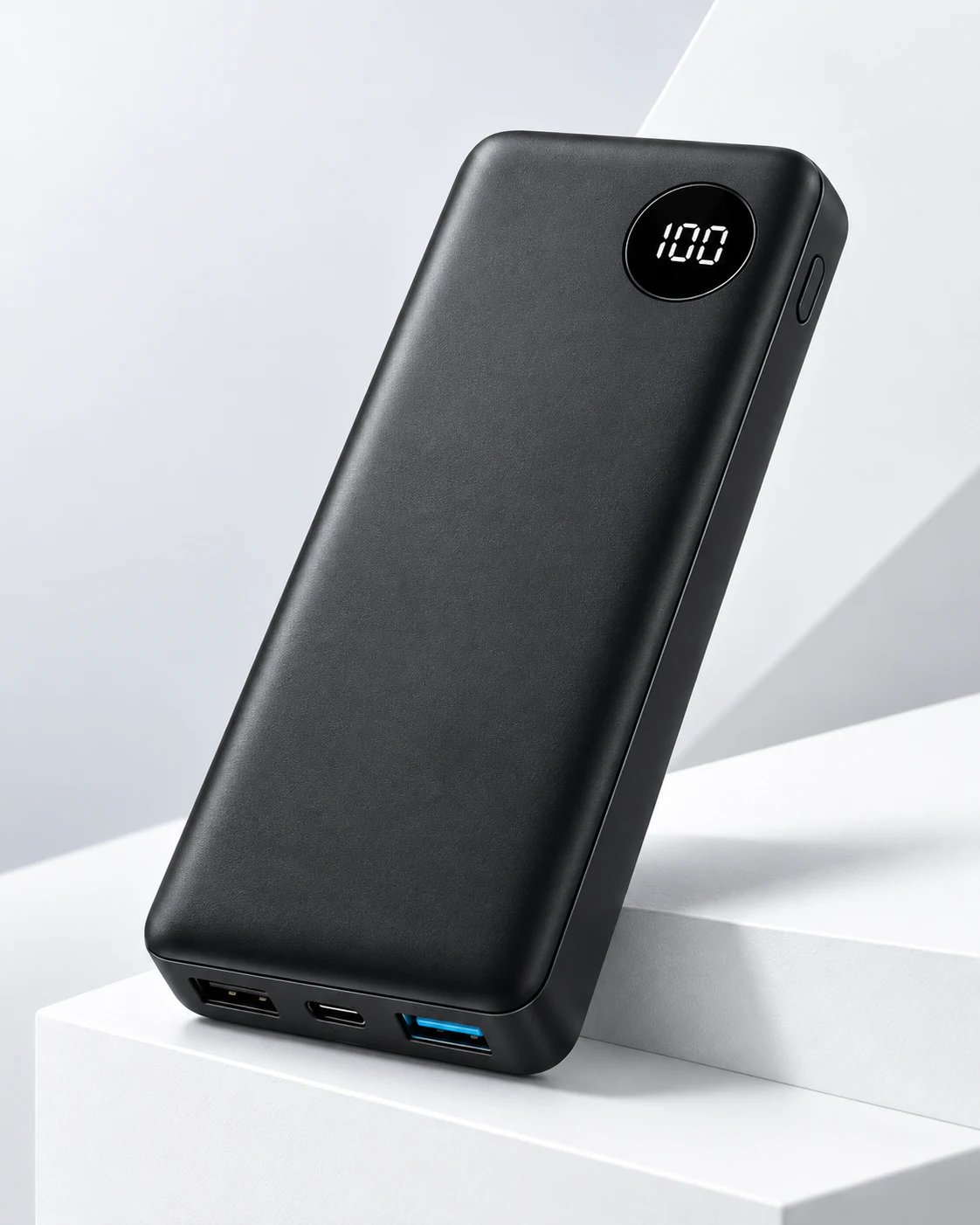Matte black high-capacity power bank on a white studio plinth
